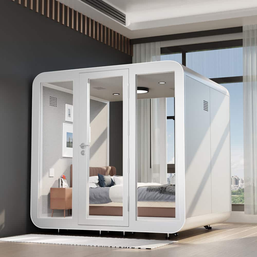 A modern, prefabricated glass-walled pod with a bed inside is situated in a spacious, sunlit room with large windows and city views. A modern, prefabricated glass walled pod with a bed inside is situated in a spacious, sunlit room with large windows and city views.